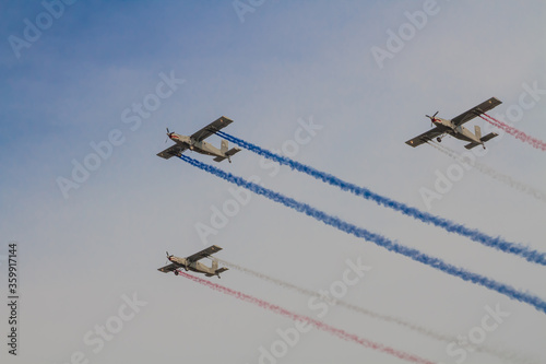 Squadron performing air show with coloured smoke releasing