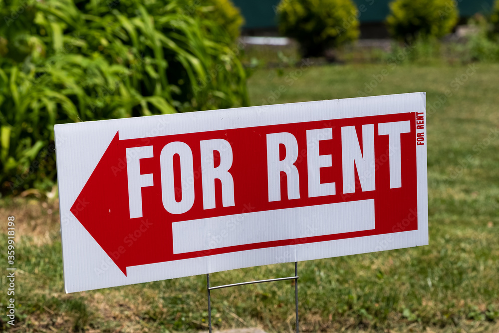 For rent sign shaped like an arrow in a yard For rent sign shaped like an arrow in a yard