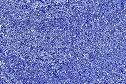 Surface texture with waves of blue color with noise and small particles.