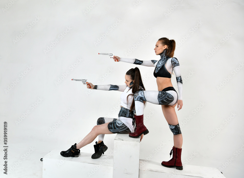 Φωτογραφία beautiful girls in robes clothes protect each other with revolvers in their hand
