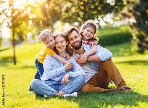 Delighted family hugging on lawn