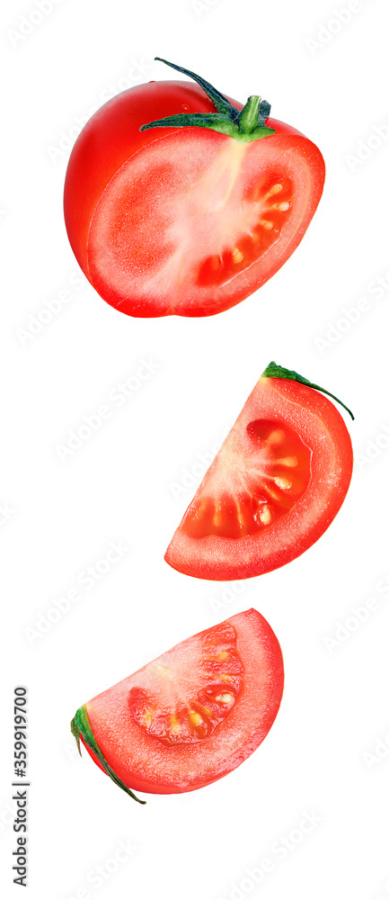 Naklejka premium Falling slices of red tomato with green leaf isolated on white background. Flying pieces of vegetables.