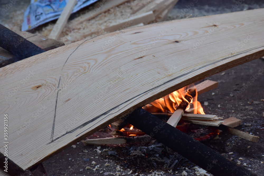 lavorazione tradizionale del fasciame di una barca in legno, piegamento a fuoco delle tavole in legno. Sicilia