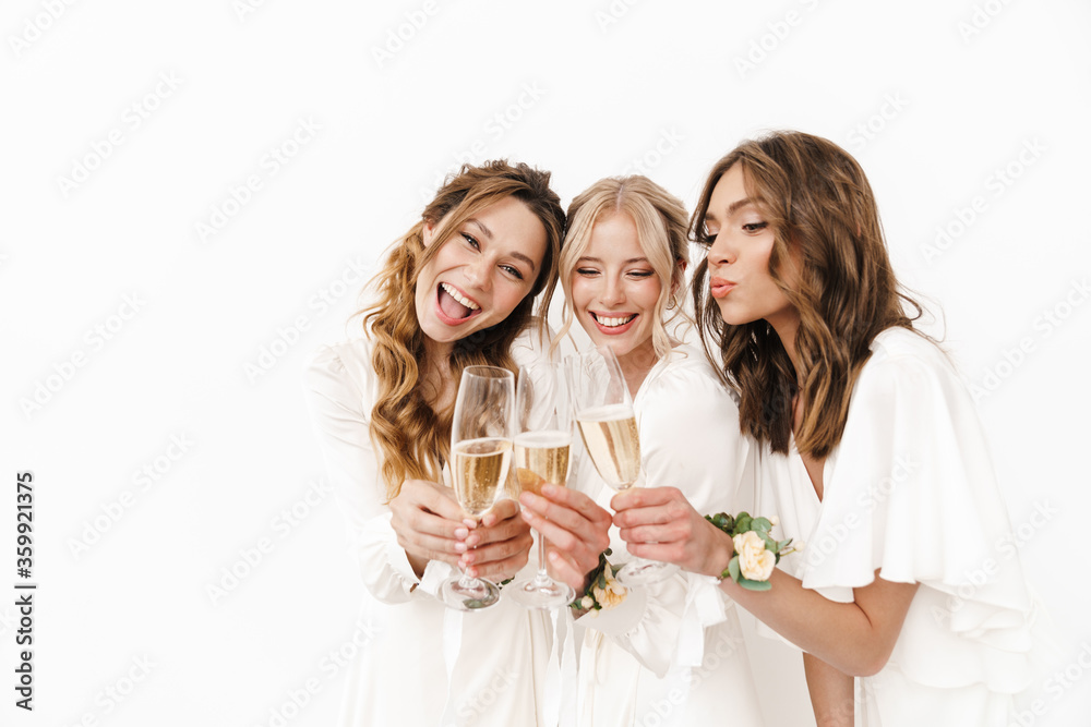 Photo of joyful beautiful bridesmaids laughing and drinking champagne Photo of joyful beautiful bridesmaids laughing and drinking champagne