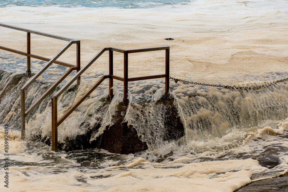 Ocean storm aftermath: A mass of thick foam covered the rock pool following extreme storm weather at Cronulla, NSW, Australia