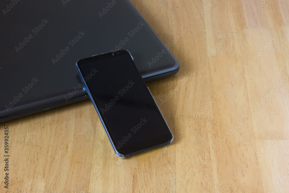 Smartphone and laptop on wooden desk for application tech mockup. Smartphone and laptop on wooden desk for application tech mockup.