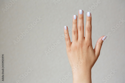 Gesture and sign, female hand showing stop on a light background. Empty space for text