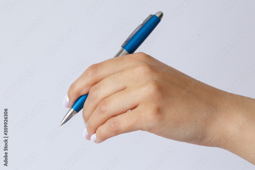Gesture and sign, female hand holding a metal blue pen on a white background Gesture and sign, female hand holding a metal blue pen on a white background