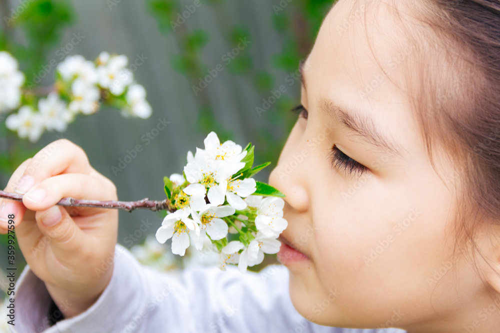 Close up portrait of an Asian girl smelling spring flowers