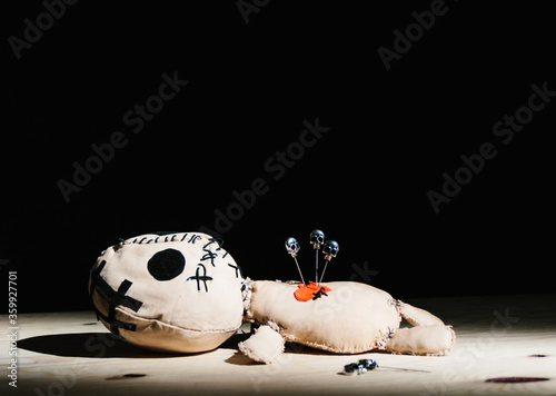 Billede på lærred Pins with skulls stabbed in a voodoo doll for your magic ritual on a black backg