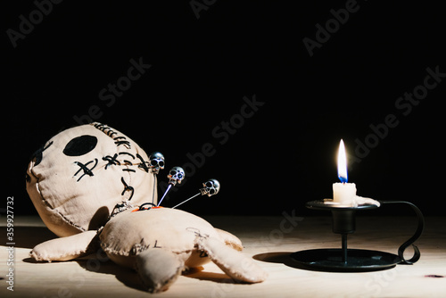 Fotografie Pins with skulls stabbed in a voodoo doll for your magic ritual on a black backg