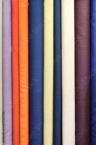 Beautiful fabrics of different colors in an upright position. Bright background image.
