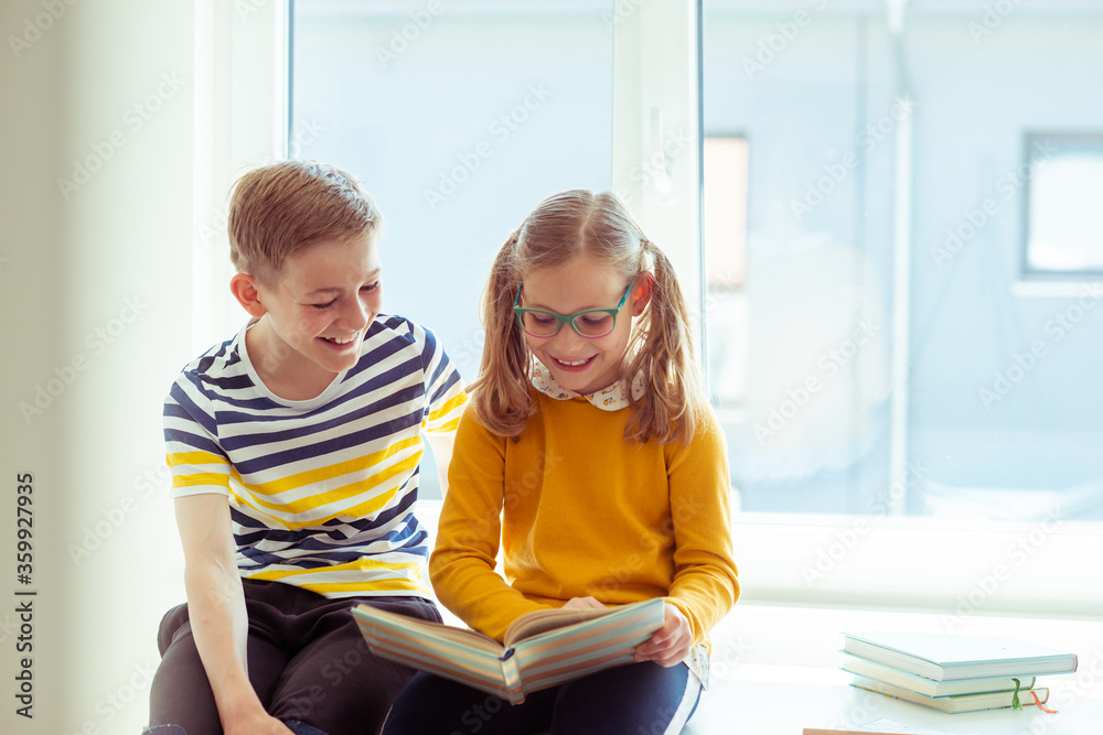 Two happy children reading funny book at holidays Two happy children reading funny book at holidays