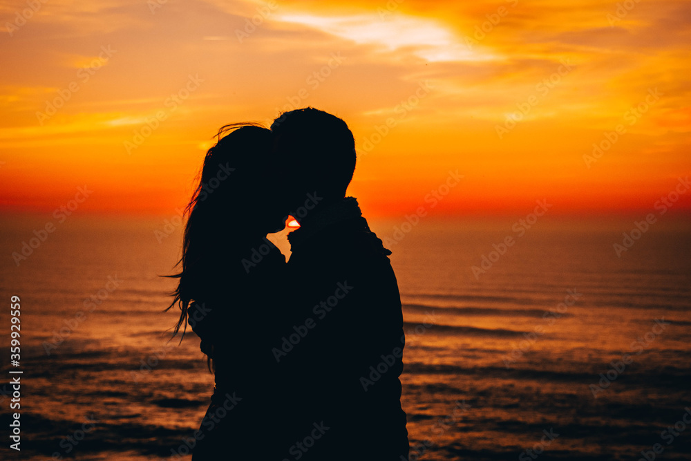 Passionate lovers dancing kizomba with a background sunset at the beach
