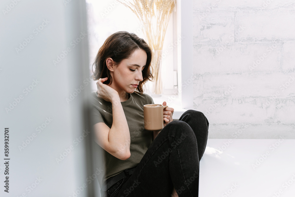 Young happy woman drinking coffee on the kitchen in the morning Young happy woman drinking coffee on the kitchen in the morning