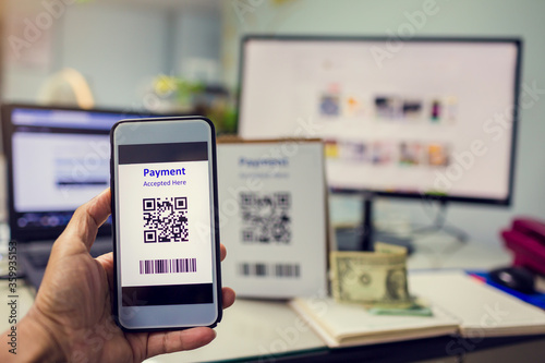 Selective focus to customer hand holding smart phone to scan Qr code payment