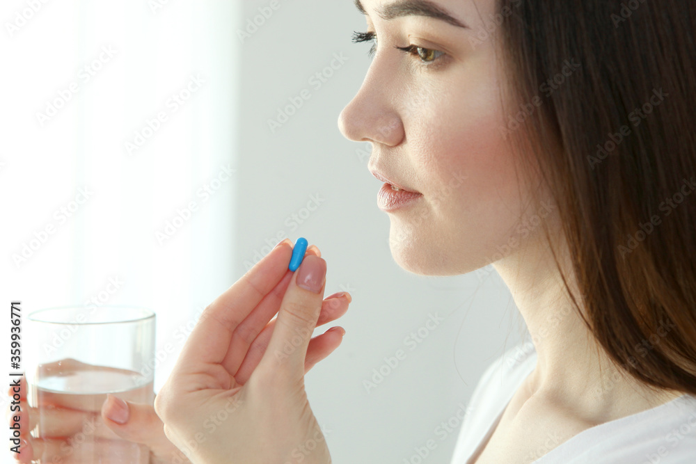 Young girl in a good mood takes pills at home
Young girl in a good mood takes pills at home