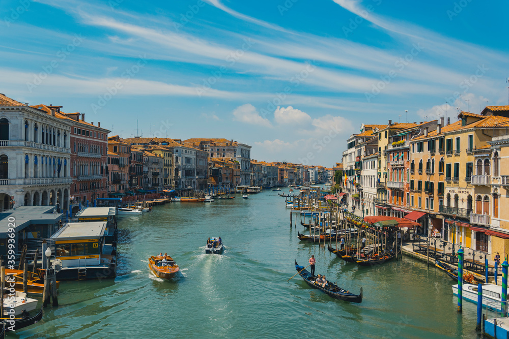Obraz premium Grand canal in venice italy, with traffic of boats and gondolas and colorful and ancient buildings, typical view of the city