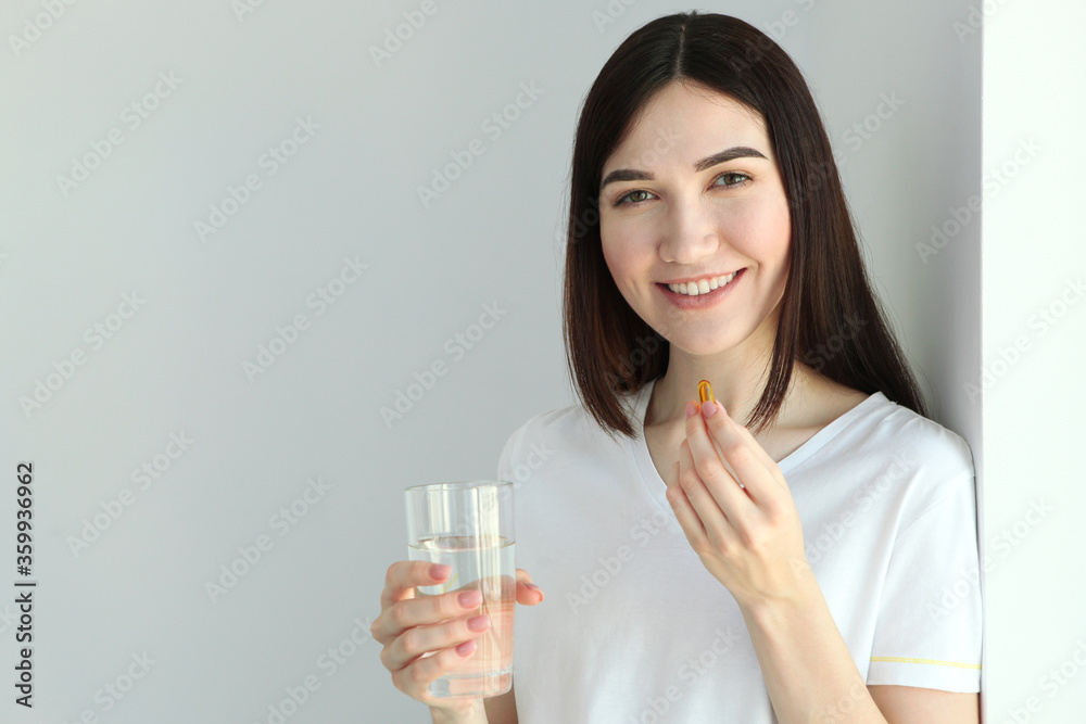 Young woman takes fish oil capsules at home
Young woman takes fish oil capsules at home