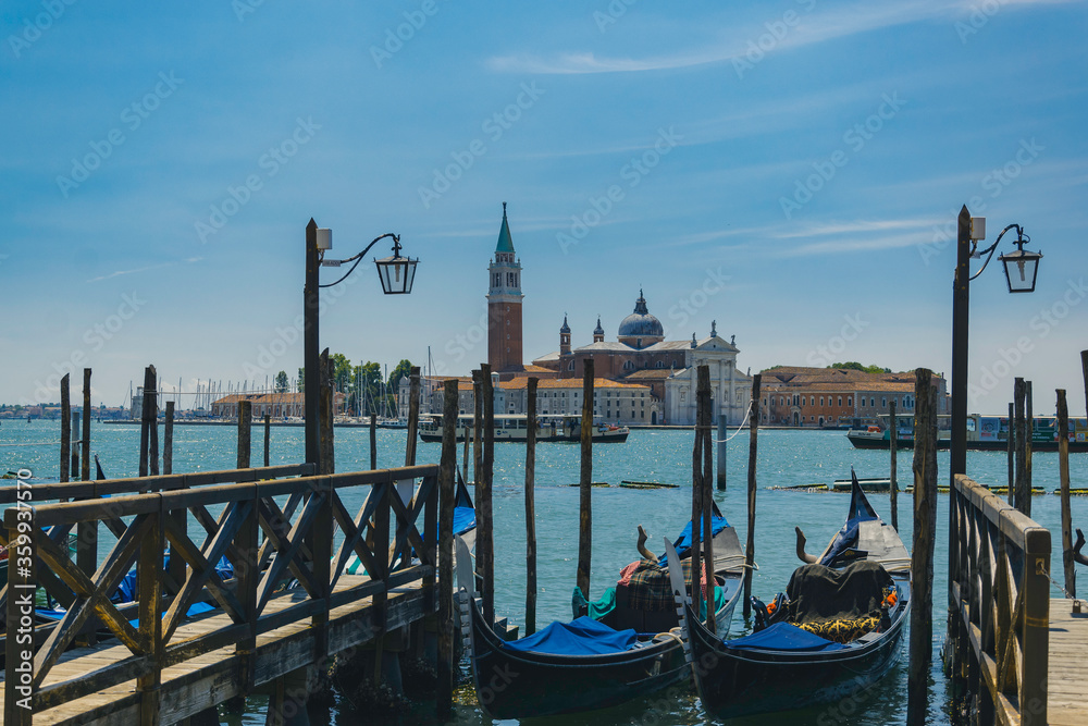 Gondolas in venice, Italy, with ancient building on an island in the distance, with sea and boats