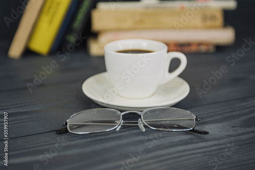 Concept on the topic of education. Books on a wooden background with coffee and glasses.