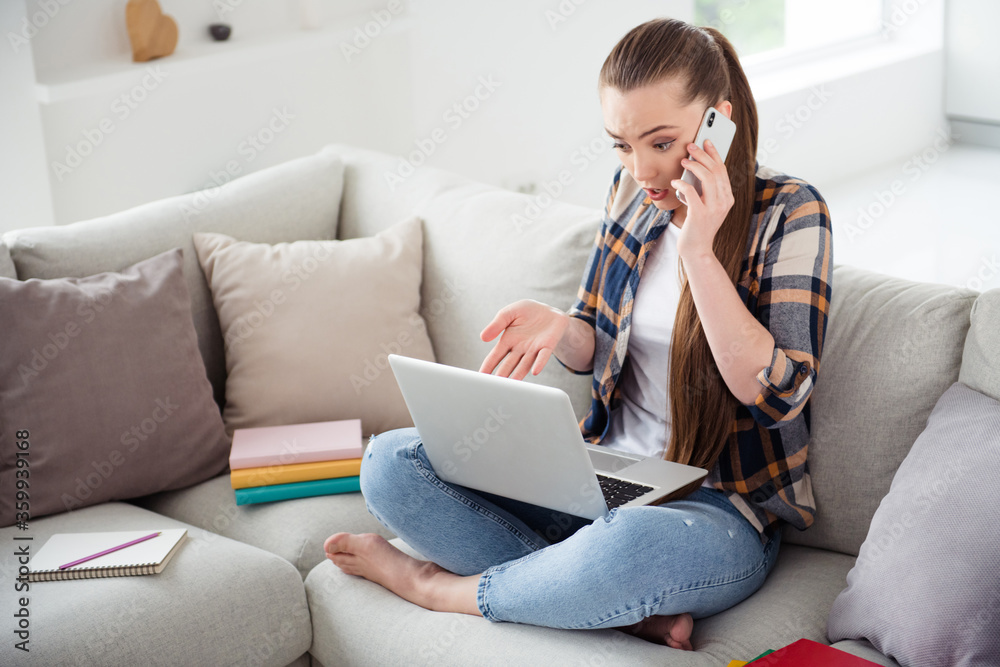 Photo of pretty lady browsing laptop notebook sit cozy couch talk telephone bad mood lesson online conference education concept look screen minded social distance quarantine indoors Photo of pretty lady browsing laptop notebook sit cozy couch talk telephone bad mood lesson online conference education concept look screen minded social distance quarantine indoors