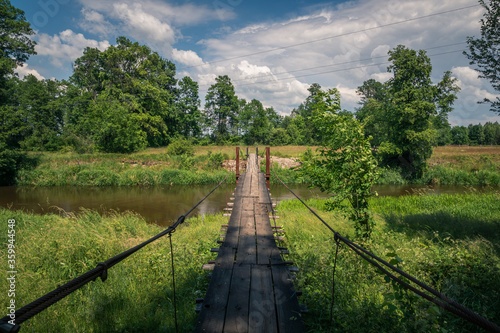 Obraz na płótnie Wooden bridge over the Liwiec river at sunny day Korytnica, Masovia, Poland w salonie