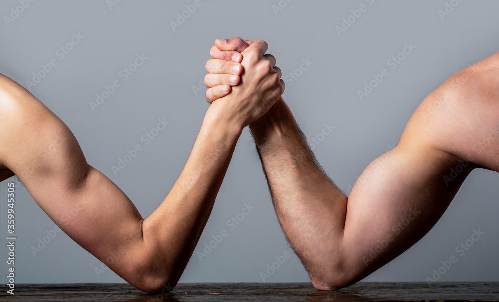 Arm wrestling. Heavily muscled man arm wrestling a puny weak man. Arm
