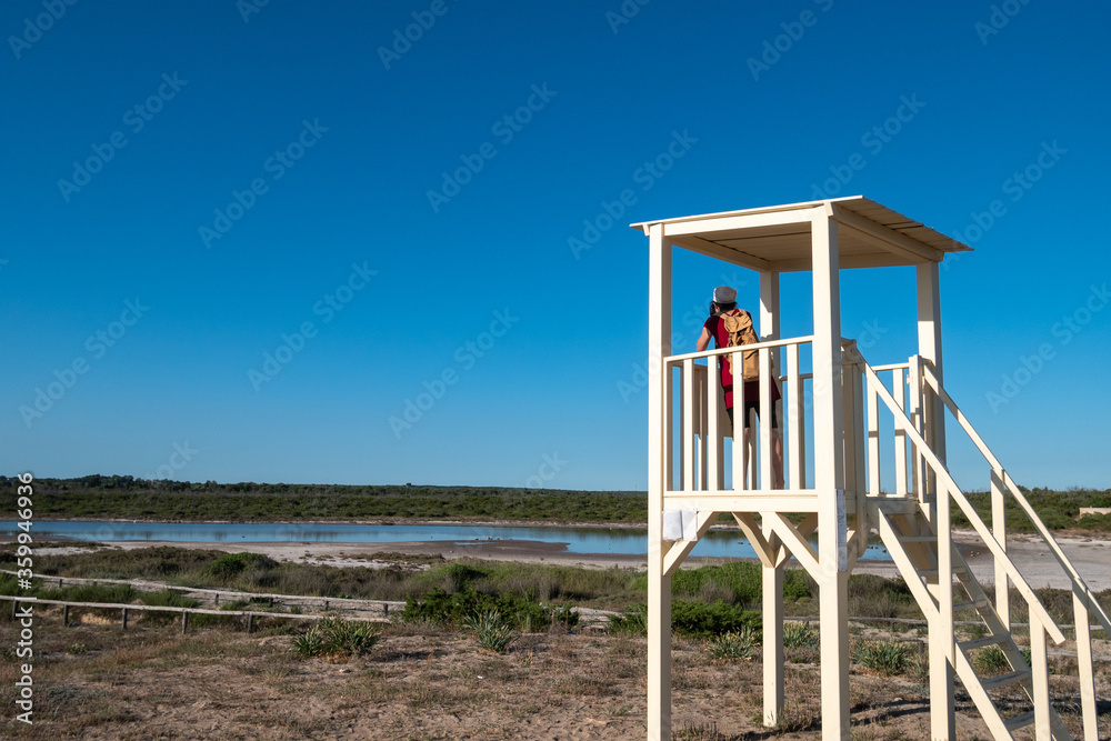 a photographer takes pictures in the Salina dei Monaci, old salt pan in the Salento, Torre Colimena, Manduria, Taranto, Apulia, Italy
