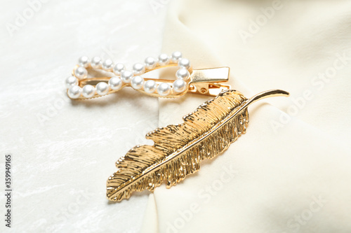 Beautiful gold hair clips and fabric on white table