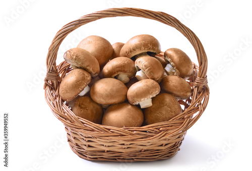 Basket full of fresh raw champignon mushrooms ready to be prepared for a healthy delicious meal, studio isolated on white