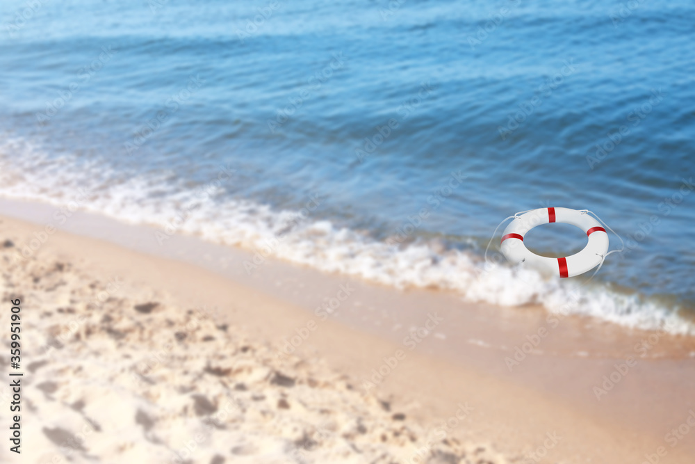 Summer water safety. Life buoy floating in blue sea Summer water safety. Life buoy floating in blue sea