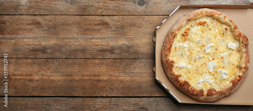 Top view of hot delicious pizza on wooden table, space for text. Banner design