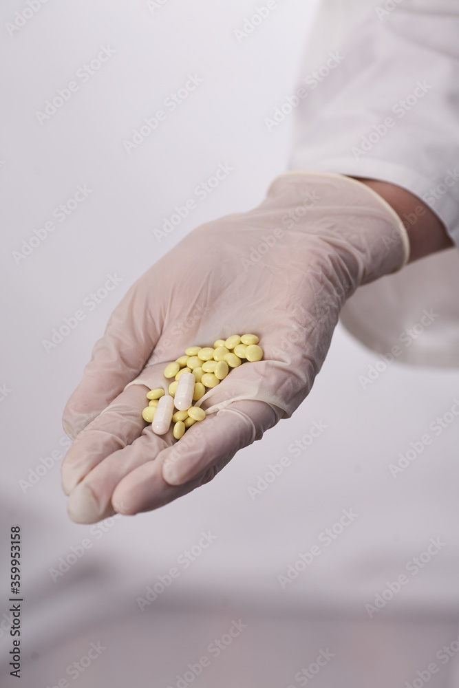 The pills are in the doctor's hands. Hands in medical gloves hold pills. Medicine for the disease. The pills are in the doctor's hands. Hands in medical gloves hold pills. Medicine for the disease.