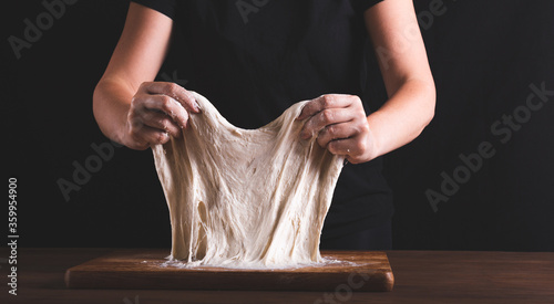 Kneading the dough method stretch end fold. .Women's hands and dough