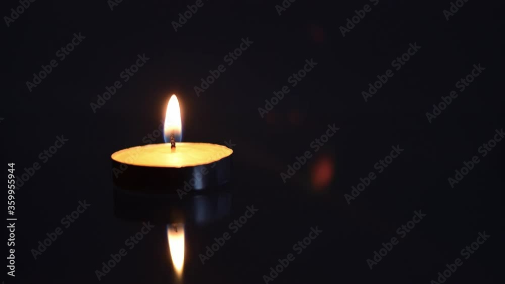Burning candle with reflection on a black background. Burning candle with reflection on a black background.