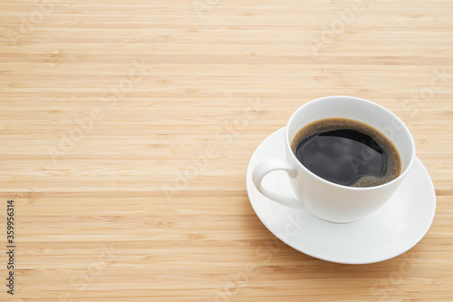 hot coffee cup in cafe on wooden bamboo table. Leave copy space empty to write the side text. soft focus.