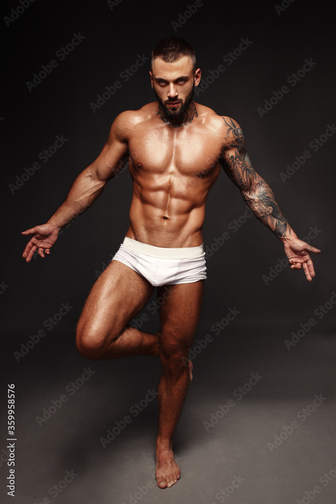 Sexy closeup portrait of handsome topless male model with beautiful eyes. Sexy man or muscular macho, bodybuilder, with muscle torso, body with six packs and abs poses on in white panties