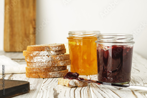 Slice of bread covered with fruit jam on wooden board