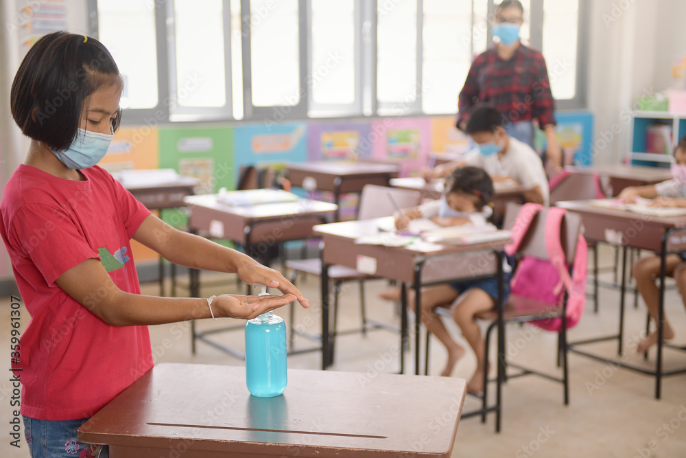 Fototapeta premium Washing Hand By Sanitizer Gel For Prevention Coronavirus Disease (Covid-19) in classroom.Washing hands by alcohol sanitizers or alcohol gel from pump bottle in public area.