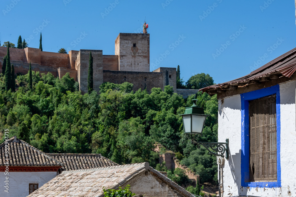 View of the Alcazaba of the Alhambra from the Albaicin with a blue-framed window in an old house