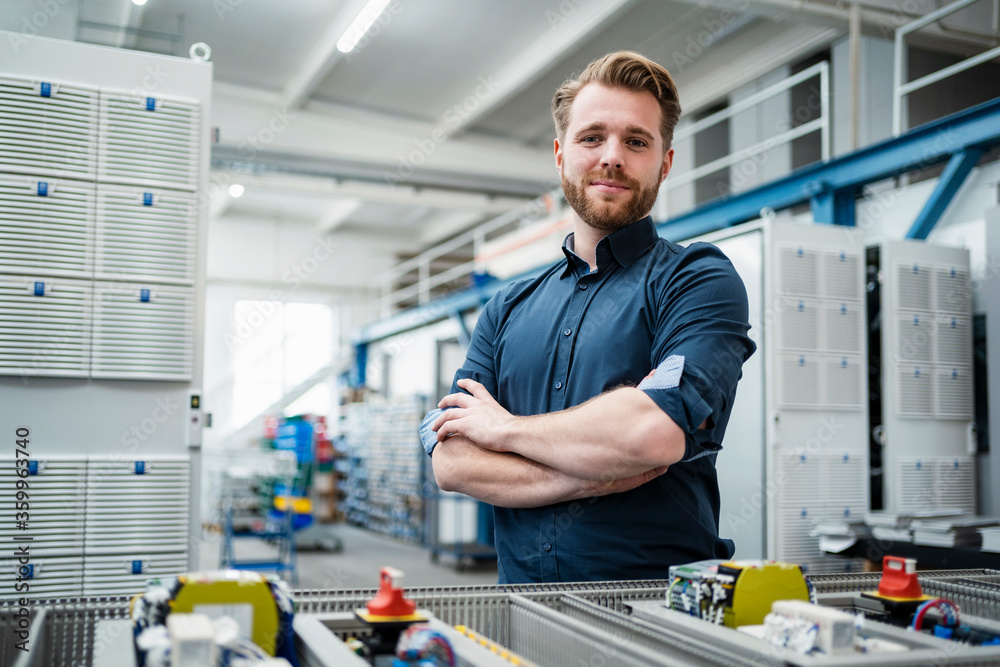 Portrait of a confident young man in a factory