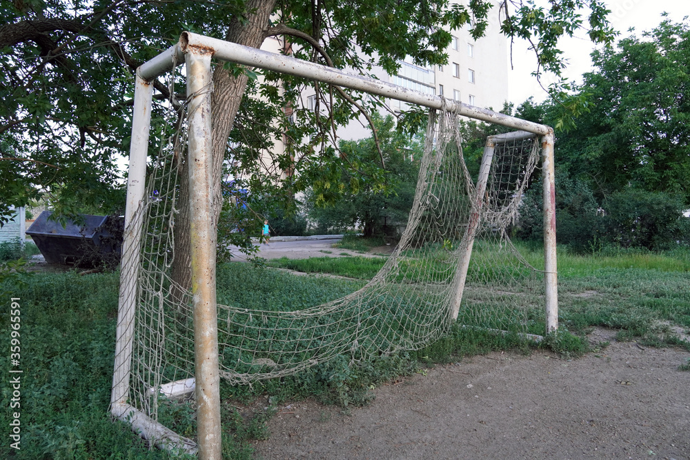 abandoned football field, goal with a torn net in a vacant lot abandoned football field, goal with a torn net in a vacant lot