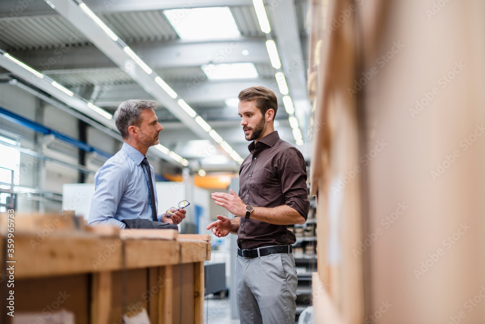Two businessmen talking in a factory Two businessmen talking in a factory