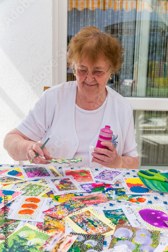 Portrait of happy senior woman painting on terrace