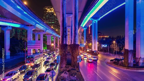 TL/ Asia, China, Shanghai, Time lapse of busy road intersection in Shanghai's financial district, with  traffic and commuters during evening rush hour, with neon lighting