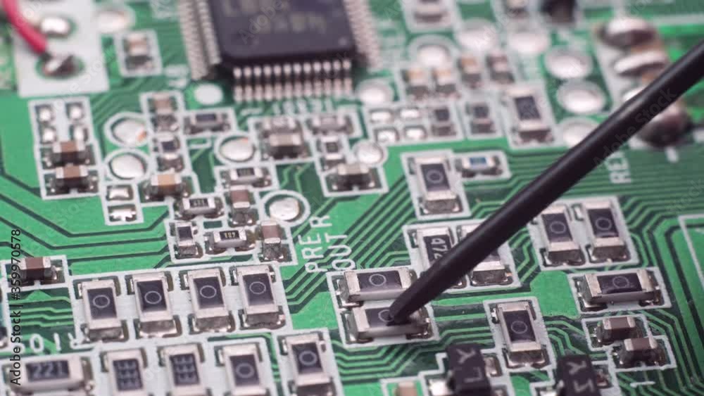 Technician repairing electronic of the computer's circuit board. Green circuit board background of PC computer motherboard. Concept technology of computer circuit hardware Technician repairing electronic of the computer's circuit board. Green circuit board background of PC computer motherboard. Concept technology of computer circuit hardware