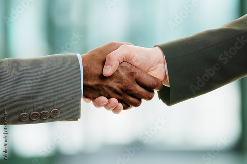 Interracial handshake on business background