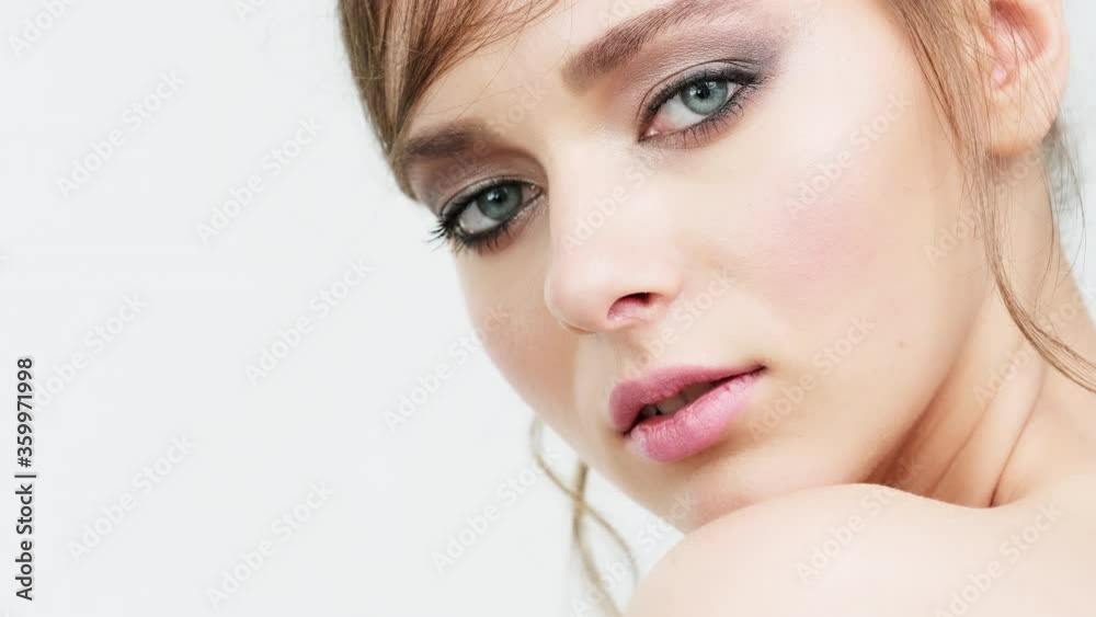 Beautiful healthy woman with fresh skin of face over white background. Young white girl looks to the camera. Woman's face with a blue eyes. Pretty caucasian model is posing before camera. Beautiful healthy woman with fresh skin of face over white background. Young white girl looks to the camera. Woman's face with a blue eyes. Pretty caucasian model is posing before camera.