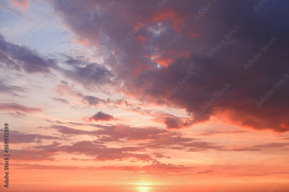 Beautiful bright colorful  pink red yellow clouds on dark sky at sunset or sunrise. Evening or morning sky natural eco background. Amazing nature texture surface wallpaper.